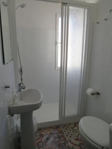 a bathroom with a toilet and a sink and a shower at Apartamentos Calypso in Punta Umbría