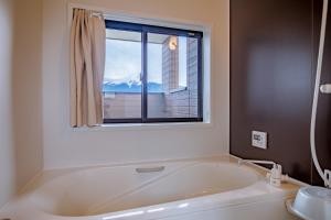 a bath tub in a bathroom with a window at SAKURA FUJI in Fujikawaguchiko +42 photos
