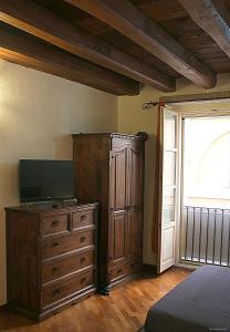 a bedroom with a television and a dresser with a window at Casa Vacanza Pablo Castello in Cagliari