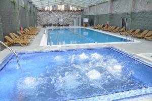 a large swimming pool with chairs in a building at Eser Diamond Hotel Spa & Convention Center İstanbul in Silivri +106 photos
