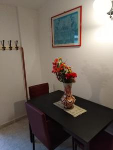stół jadalny z wazonem kwiatów w obiekcie Casa Natura sotto il Castello w mieście Castelbuono