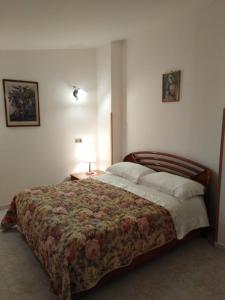 una camera da letto con un grande letto con un copriletto floreale di Casa Natura sotto il Castello a Castelbuono