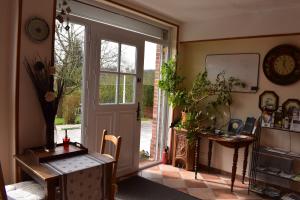 a room with a door and a table and a desk at Les Trois Pommiers in Sommery