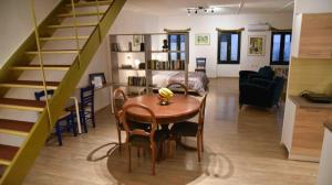 sala de estar con mesa de comedor y escalera en Ulysses Apartments Monastiraki, en Atenas