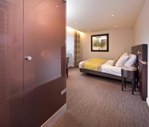 a hotel room with a bed and a sliding door at Logis Hotel Restaurant Muller in Niederbronn-les-Bains +27 photos