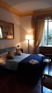 a bedroom with a bed and a lamp and a window at Florian in La Spezia