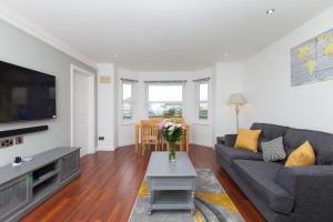 Super Prime Duloch - Dunfermline - 2 Bed Executive Apartment في دنفرملاين: غرفة معيشة مع أريكة وتلفزيون
