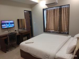 En eller flere senge i et værelse på Visawa Palace Nanded