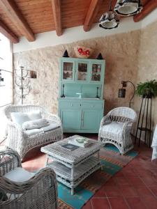 a patio with wicker chairs and a table and a cabinet at A Lumia in Noto