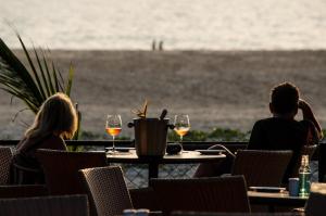 a couple sitting at a table with wine glasses at Beleza By The Beach in Colva