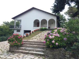 uma casa branca com escadas e flores em frente em Casa del Sole, Villa indipendente isolata in area verde perfetta smart-working em Riccò del Golfo di Spezia