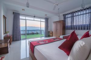 a bedroom with a bed and a large window at Beauty Hills in Kandy