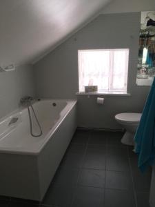 スティッキスホールムルにあるHöfðiのバスルーム(バスタブ、トイレ付)、窓が備わります。