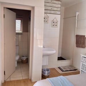 une salle de bain avec un lavabo et des toilettes dans l'établissement Vincentia Odd Cottage ( self catering), à East London 13 autres photos