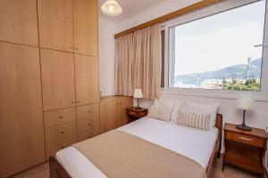 sypialnia z łóżkiem i dużym oknem w obiekcie House of Hats - next to the coast - Karavomylos w mieście Karavomylos