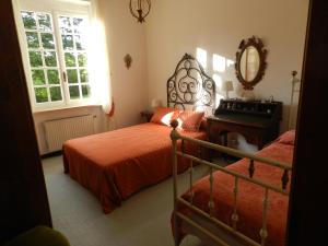 um quarto com 2 camas, um espelho e um piano em Casa del Sole, Villa indipendente isolata in area verde perfetta smart-working em Riccò del Golfo di Spezia