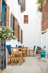 a patio with wooden chairs and a table at Vassos Apartments in Líndos