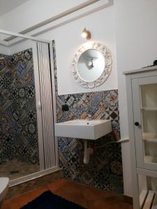 bagno con lavandino e specchio di Bed and breakfast Agrumi in terrazza ad Aragona