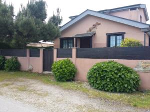 ein Haus mit einem Zaun und ein paar Büschen in der Unterkunft Casita de Folgosa in Ribadeo