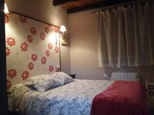 a bedroom with a bed with a red and white blanket at Casita de Folgosa in Ribadeo