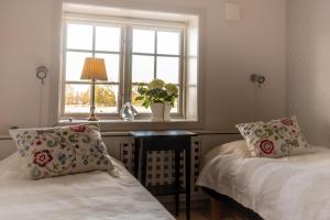 sypialnia z 2 łóżkami i oknem w obiekcie Rekasta Bed & Breakfast w mieście Enköping