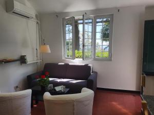 a living room with a couch and a table and two windows at La Merella in Rapallo