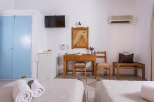 a living room with a bed and a table and a desk at Hotel Olympia in Karterados