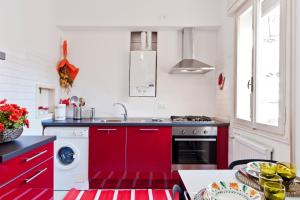 een keuken met rode kasten en een wastafel bij CA SUSANNA NEAR TRAIN STATION in Venetië