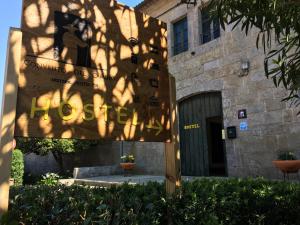 a building with a shadow on the side of it at Albergue Convento Del Camino in Tui