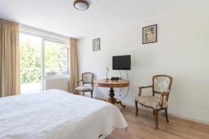 1 dormitorio con 1 cama, mesa y sillas en Bed and Breakfast Hoorn, en Hoorn