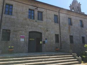 an old building with a clock on the front of it at Albergue Convento Del Camino in Tui