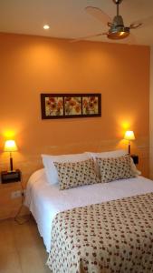 a bedroom with a white bed with two lamps at Casa Magnolias in Tandil +51 photos