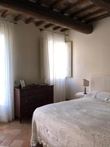 a bedroom with a bed and a dresser and a window at Le Case Di San Vitale Easy in Ravenna