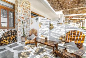 a patio with two chairs and a table and a fireplace at Limeri Traditional Guest House in Monólithos