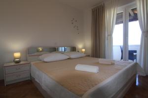 een slaapkamer met een groot bed met 2 witte kussens bij Apartmani GORDANA in Mali Lošinj