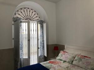 1 dormitorio con 1 cama y puerta abierta en Jano PuertaTierra, en Cádiz