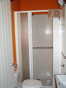 a bathroom with a toilet and a glass shower at Casita de Folgosa in Ribadeo