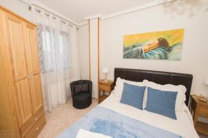 a bedroom with a bed and a painting on the wall at VUT LOS RECUERDOS DE SANDRA in El Barco de Ávila