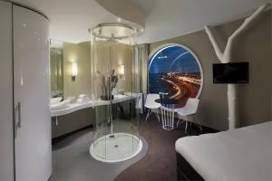 a hotel room with a bed and a glass shower at Fletcher Hotel Amsterdam in Amsterdam