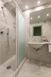 bagno bianco con lavandino e doccia di Hotel Palazzo dal Borgo a Firenze