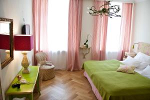 a bedroom with a green bed and a table and a mirror at das HOTEL in München in Munich