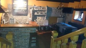 un bar dans un restaurant avec un mur en pierre dans l'établissement El Cantiellu, à Zardón