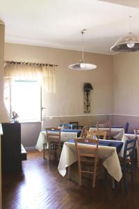 ein Esszimmer mit Tischen und Stühlen und einem Fenster in der Unterkunft Vesuviane 'E Belle 'Mbriane B&B in Neapel