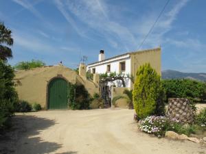 a house with a green door on a dirt road at River Ebro Holidays in Tivenys