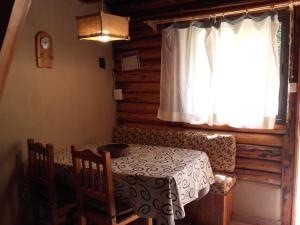 a dining room with a table and a window at CABAÑAS LOS PATOS in Lago Puelo