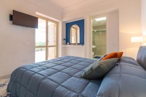 um quarto com uma grande cama azul e uma janela em La Gioiella Capri em Capri