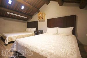 a bedroom with two beds with white sheets and wooden ceilings at Water 97 in Jincheng