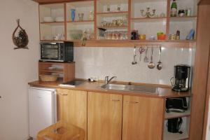 eine Küche mit einer Spüle und einer Mikrowelle in der Unterkunft Wohnung 3 in Ostseebad Nienhagen