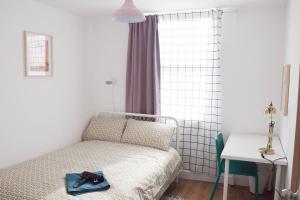 ein Schlafzimmer mit einem Bett mit einem Paar Schuhe darauf in der Unterkunft GRANBY APARTMENTS F-1 in Leicester