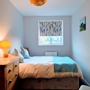 a bedroom with a bed with a dresser and a window at 80 Bedford Place in Southampton